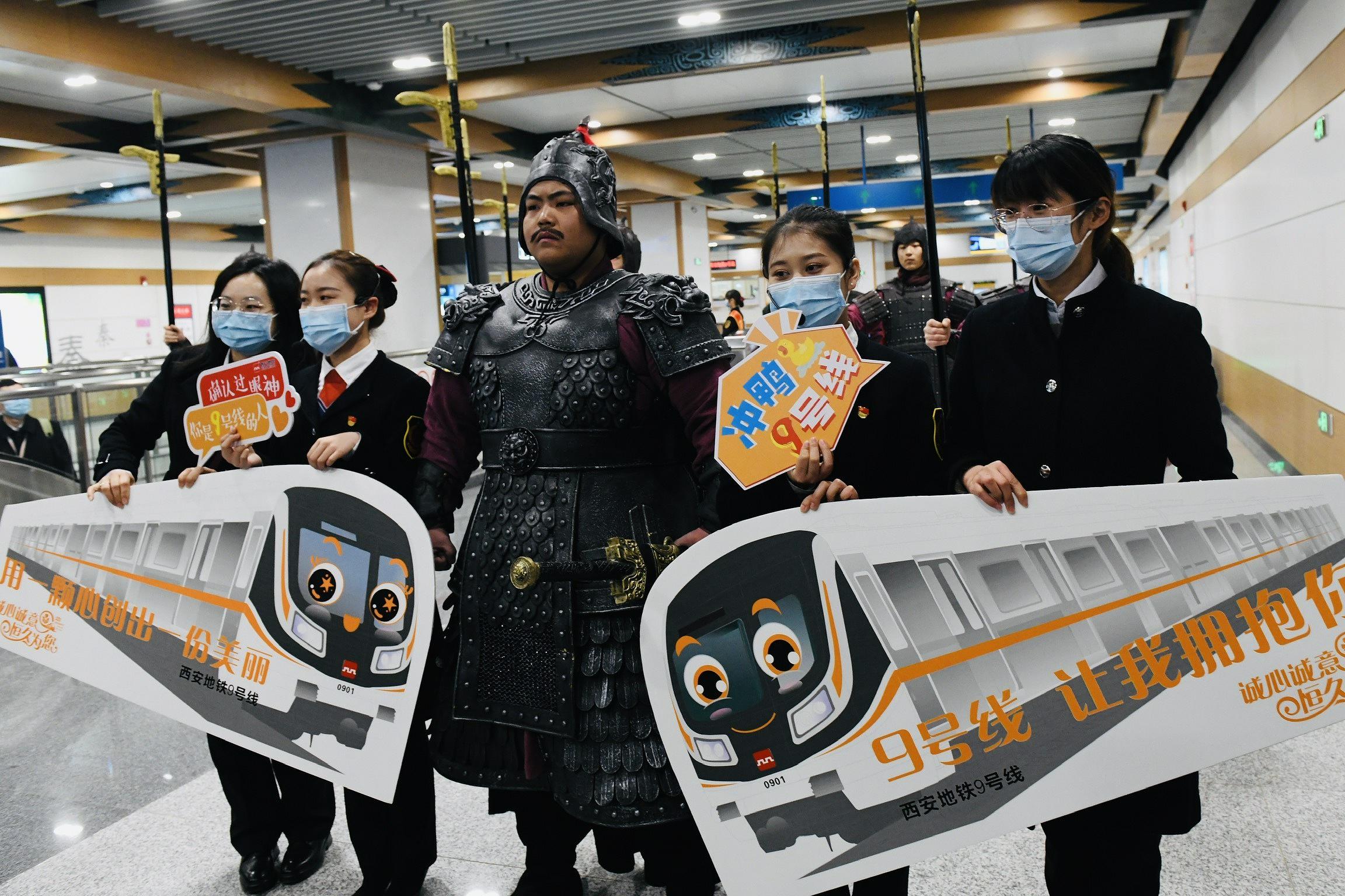 12月9日、秦陵西駅で、地下鉄アテンダントたちと記念撮影する「兵馬俑」（写真著作権はCFP視覚中国が所有のため転載禁止）。