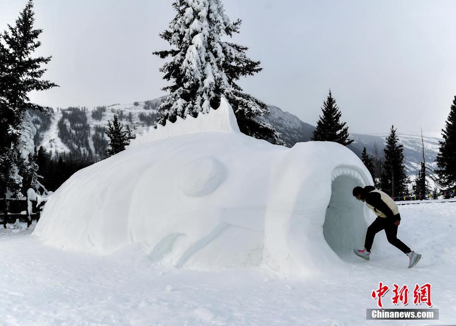 12月23日、ユニークな巨大魚の雪像に入っていく観光客（撮影・劉新）。