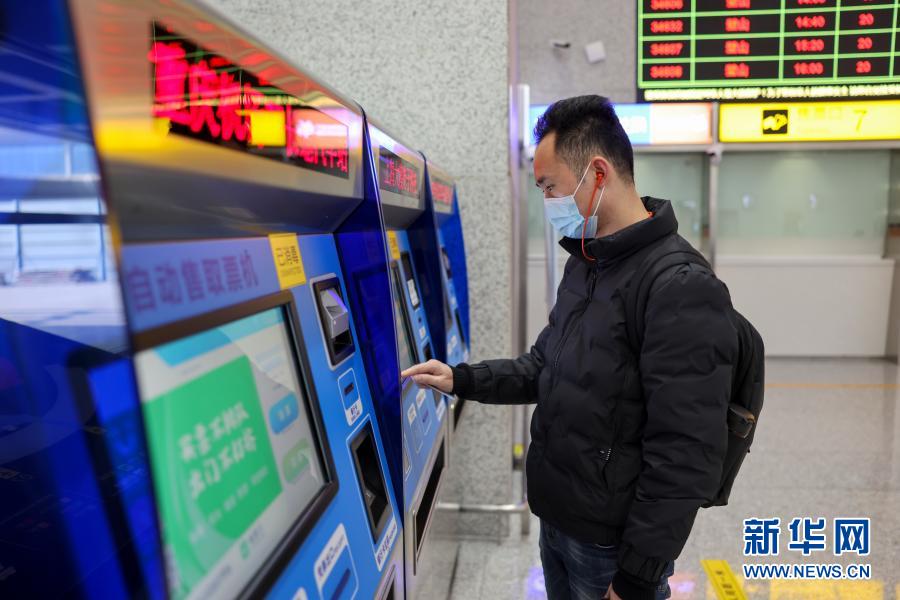 1月14日、重慶江北国際空港ターミナルビルT3Aにある長距離バスターミナル乗車券売り場で、予約済の長距離旅客輸送専用ミニバン路線の乗車券を自動券売機で発券する乗客（撮影・劉潺）。