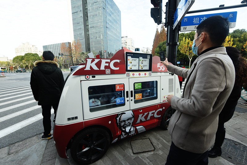 2020年12月17日、上海の街頭に置かれた5Gスマート無人朝食車でコードをスキャンし、朝食を購入する市民。竜巍/人民図片