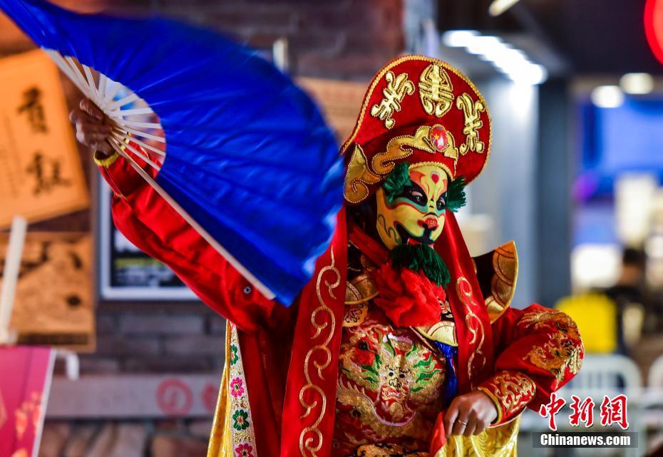 2月7日、新疆維吾爾（ウイグル）自治区烏魯木斉（ウルムチ）市南部にある懐かしい雰囲気を漂わせるグルメエリアで、四川省の伝統芸能「変臉」のパフォーマンスを行うパフォーマー（撮影・劉新）。