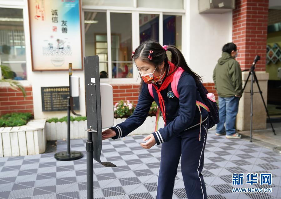 2月22日、上海市徐匯区建襄小学校で、登校時に手や指を消毒する生徒（撮影・丁汀）。