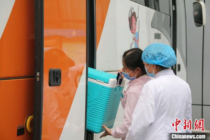 出発前、新型コロナワクチンの移動型接種カーにワクチンを積み込む病院職員（撮影・彭国威）。