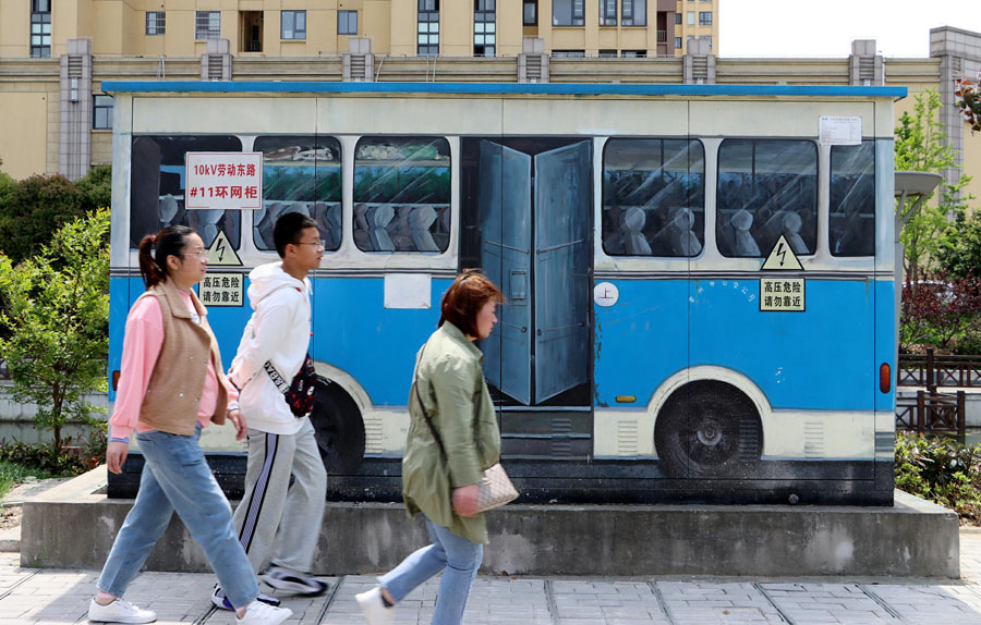 4月18日、懐かしいデザインのバスが描かれたボックスの傍を通る市民（写真著作権はCFP視覚中国が所有のため転載禁止）。