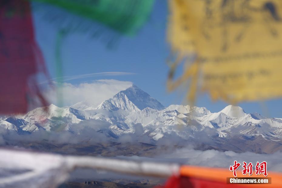 5月9日、加吾拉山の峠から望むチョモランマ。色とりどりのタルチョー(チベットの祈祷旗)と純白の雪が互いに引き立て合っている（撮影・冉文娟）。