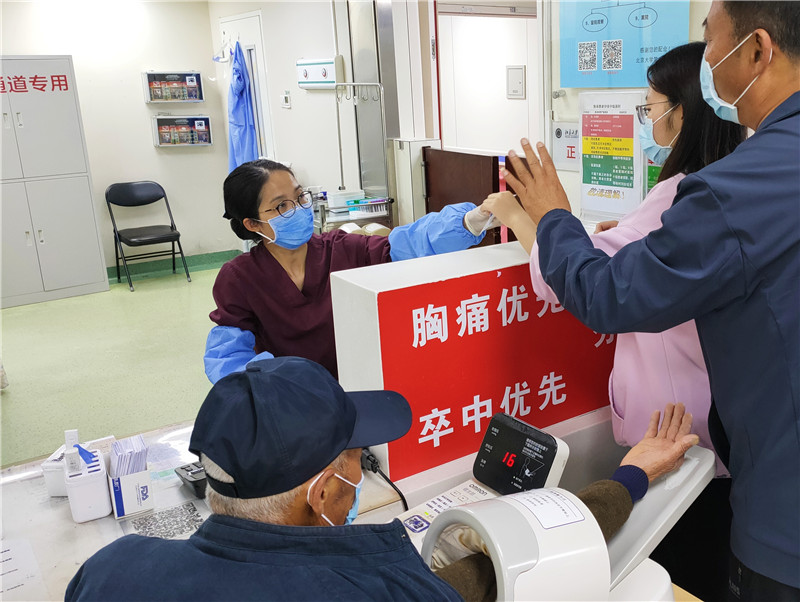 北京大学第一病院救急科で、看護師から入院に関する質問を受ける患者（撮影・喬業瓊）。