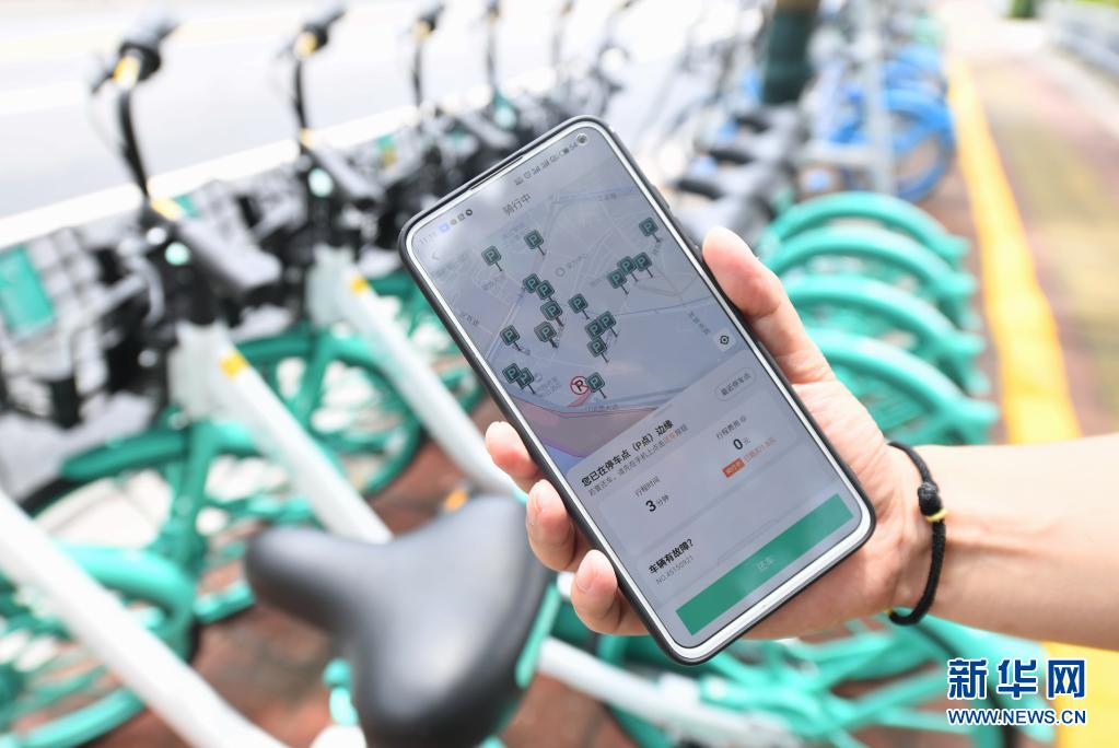 福建省福州市台江区で、シェア自転車指定駐輪エリアの情報をスマホアプリで表示するスタッフ（6月1日撮影・林善伝）。