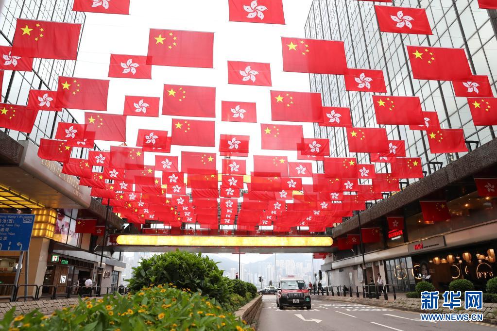 6月29日、香港地区尖沙咀のある通りで、風にはためく中華人民共和国の国旗と香港特別行政区の区旗（撮影・李鋼）。
