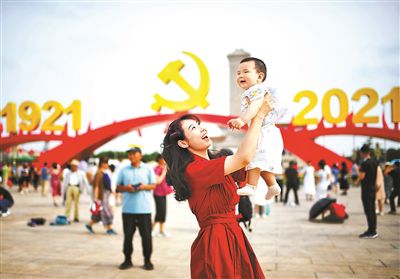 天安門広場の中国共産党党章と年号の前で記念撮影をする女性（撮影・郝羿）。