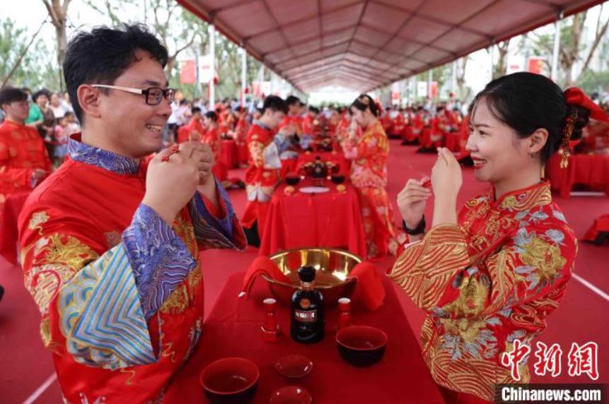 伝統的な赤い結婚衣装を着て、伝統的な結婚式に参加した50組の新婚カップル（撮影・謝琛）。