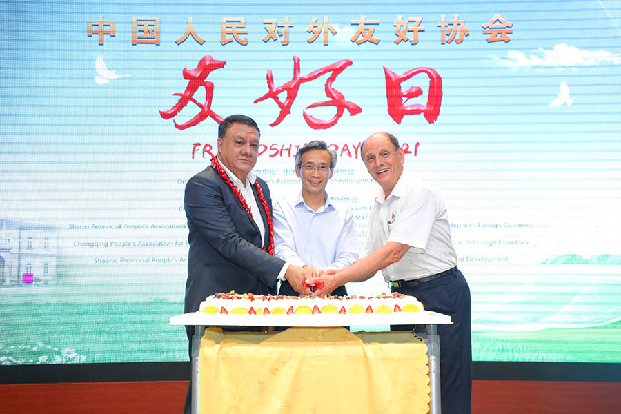 　「フレンドシップデー」を祝うケーキに入刀する中国人民対外友好協会林松添会長（写真中央）、在中国サモア大使（写真左）、ICCICのMichael Crook会長（写真右、写真は主催者が提供）。