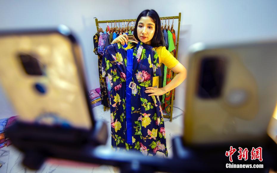 新疆ウルムチ市地王商品城EC産業園のライブ配信スタジオで5日、ライブコマースで衣料品を販売する努熱曼・木沙さん（撮影・劉新）。