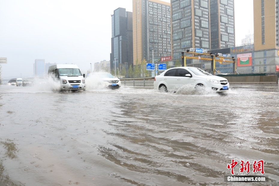 鄭州市市街地で、冠水した道路を走行する車両（撮影・闞力）。
