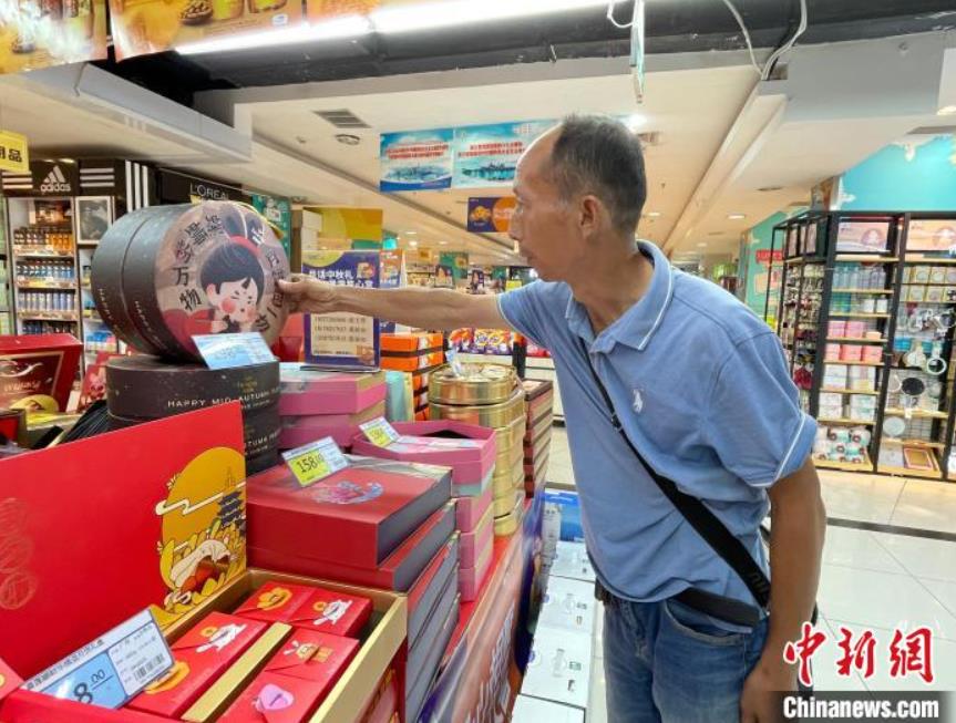 スーパーマーケットで「タニシ麺入り月餅」を買い求める市民（撮影・林馨）。