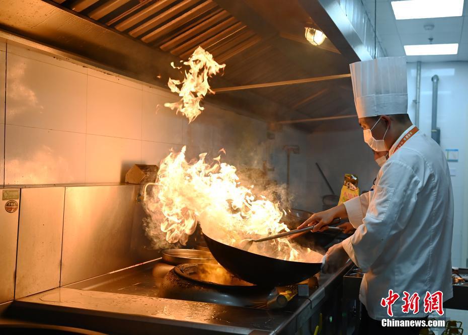 陝西省西安市で開催されている第14回全国運動会の選手村レストランで調理をする調理師たち（撮影・安源）。