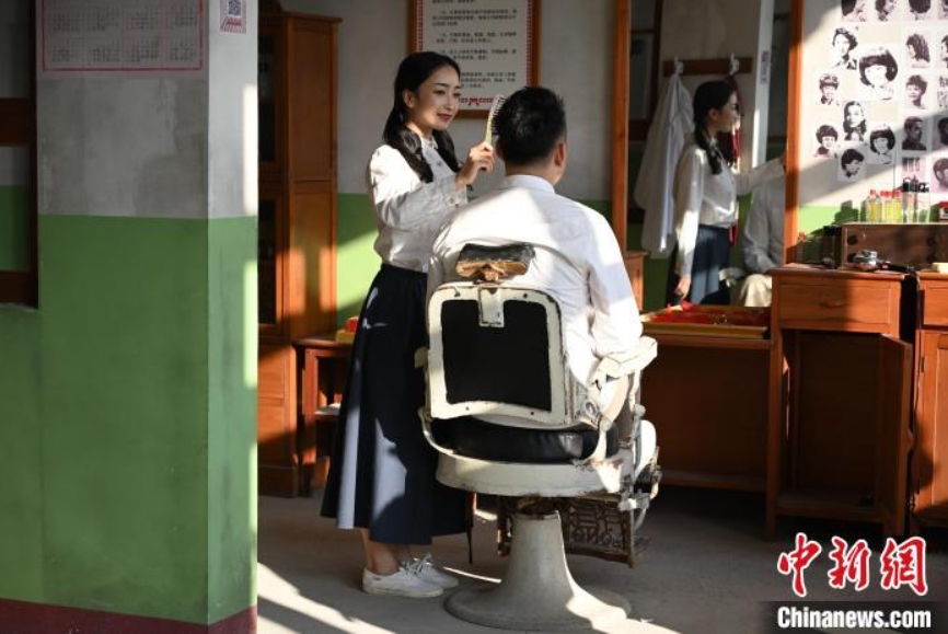 10月9日、映画・テレビ撮影所の理髪店を見学する若者（撮影・劉文華）。