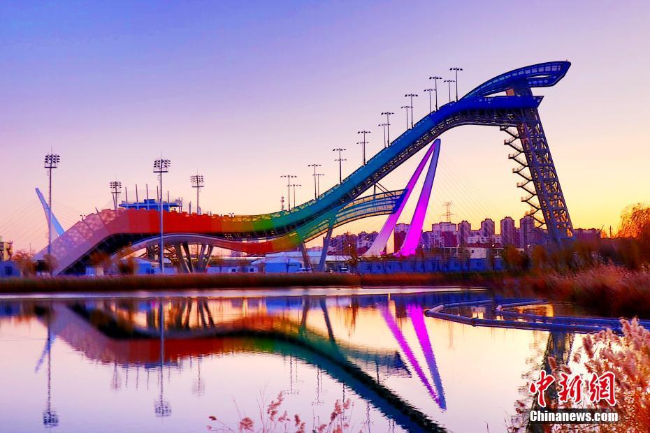 夕陽に映える北京冬季五輪公園の首鋼ジャンプ台と首鋼大橋