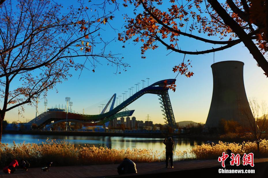 夕陽に映える北京冬季五輪公園の首鋼ジャンプ台と首鋼大橋