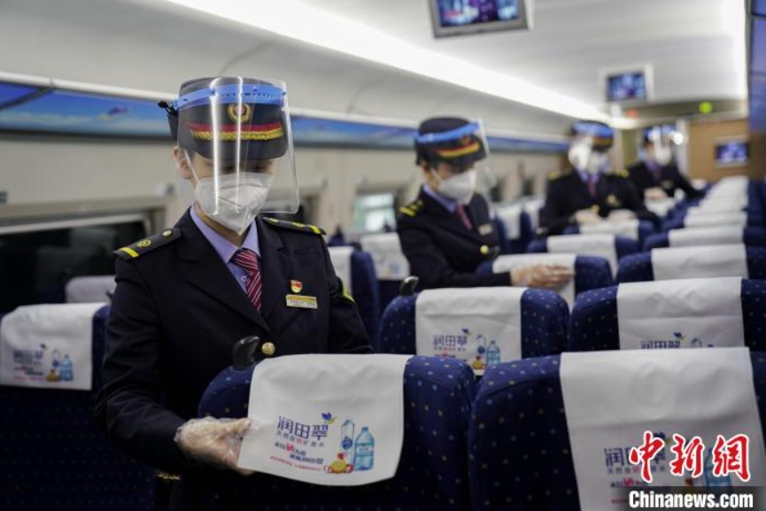 座席のヘッドカバーを整える南昌旅客輸送区間高速鉄道乗務員（撮影・張学東）。
