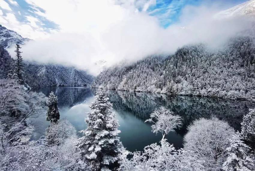 青く澄んだ水面に映る純白の雪景色（写真提供・九寨溝）。
