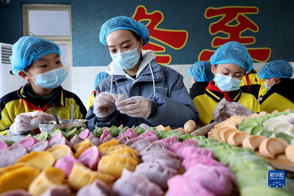 12月20日、山東省棗荘市市中区中興小学校で、餃子の包み方を児童に教える教員（写真左から2番目、撮影・孫中喆）。