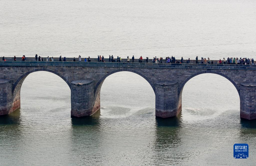 12月26日、安徽省黄山市屯渓区で、修復工事が完了した鎮海橋を通行する市民（撮影・施亜磊）