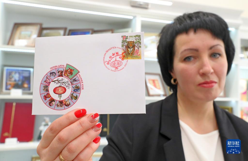 1月18日、ベラルーシの首都ミンスクで、干支である寅を題材にした記念切手と初日の消印スタンプを見せる職員。