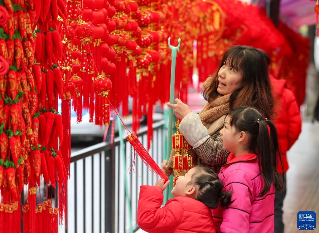 1月23日、貴州省銅仁市玉屏侗（トン）族自治県の正月用品市場で、春節の飾りを購入する市民（撮影・胡攀学）。