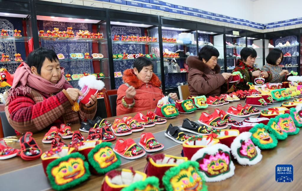 1月24日、河南省洛陽市汝陽県小店鎮高荘村にある工場で、子供用布靴「虎頭鞋」を制作する現地村民（撮影・康紅軍）。
