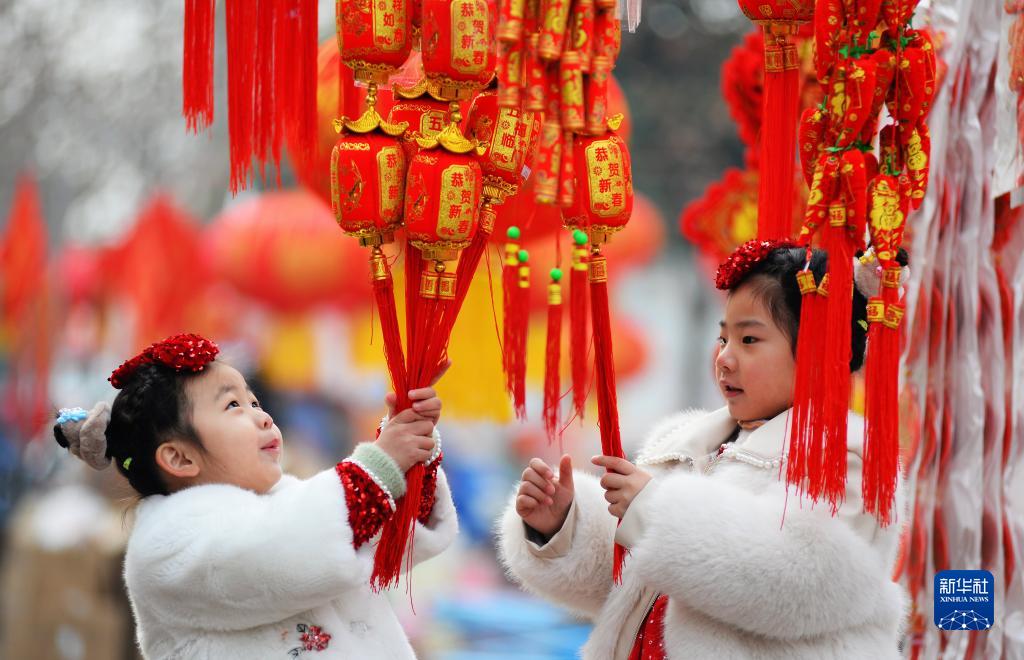 1月25日、山東省滕州市の正月用品市場で春節の飾りを見る子供たち（撮影・李志軍）。