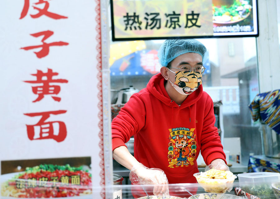 2月5日、大バザール景勝地のグルメ街で、観光客のためグルメを準備する、「虎のマスク」を着用した従業員（写真著作権はCFP視覚中国が所有のため転載禁止）。