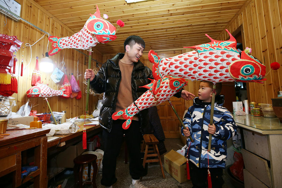 2月7日、魚灯籠で遊ぶ許賓さんと子供（写真著作権はCFP視覚中国が所有のため転載禁止）。