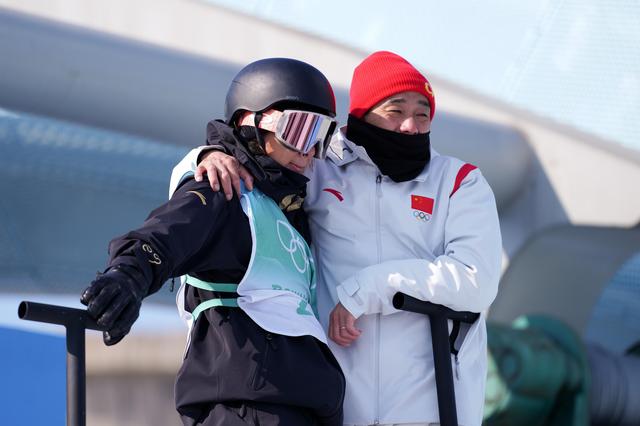 2022年2月15日、北京冬季五輪スノーボード男子ビッグエア決勝で、最後の試技を前にした蘇翊鳴選手と佐藤康弘コーチ（右、撮影・熊琦）。