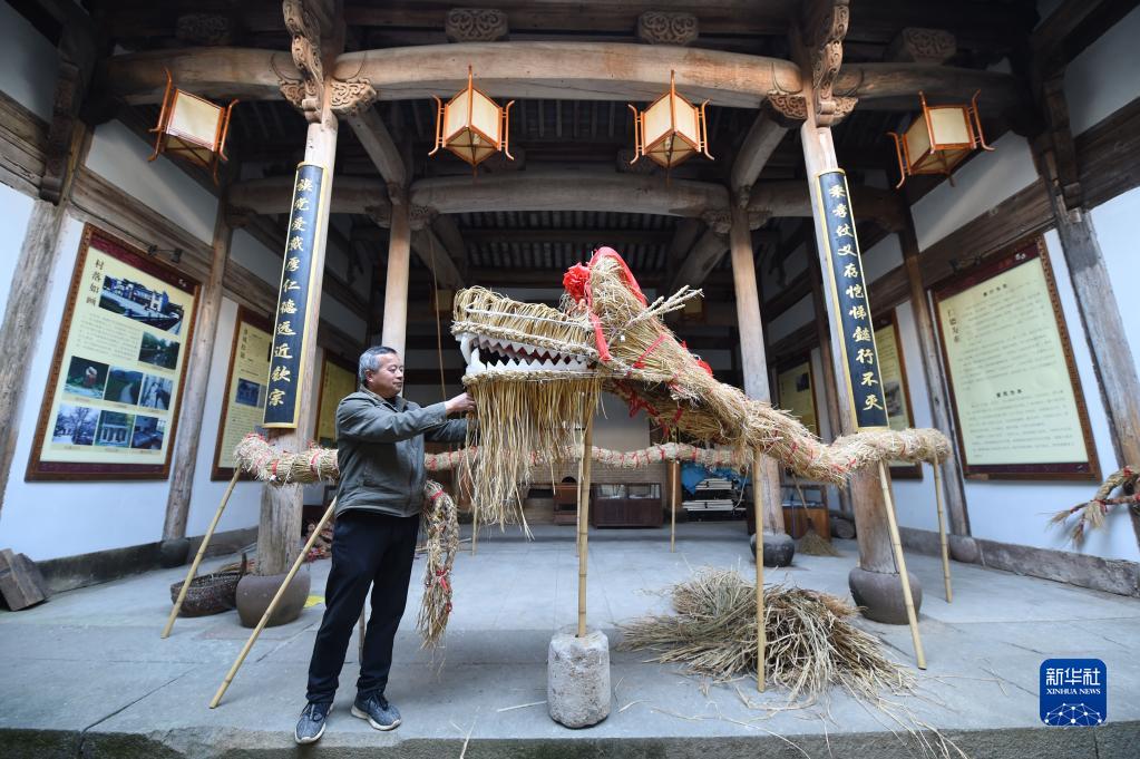 3月2日、黄山市徽州区蜀源村で、編み終えた「草の竜」をチェックする村民（撮影・周牧）。