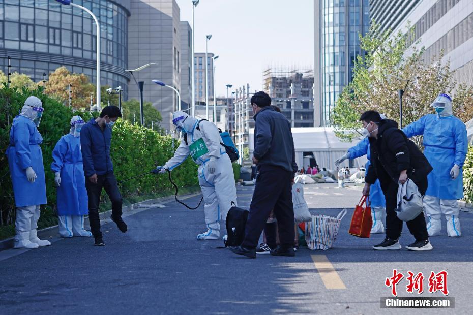 4月9日、上海市普陀区の上海跨国采購会展センターに設けられた方艙医院（臨時医療施設）で、各自荷物を持ち、医院を出て自宅に戻るための車両に乗る準備をする第一陣回復患者の4人（撮影・殷立勤）。