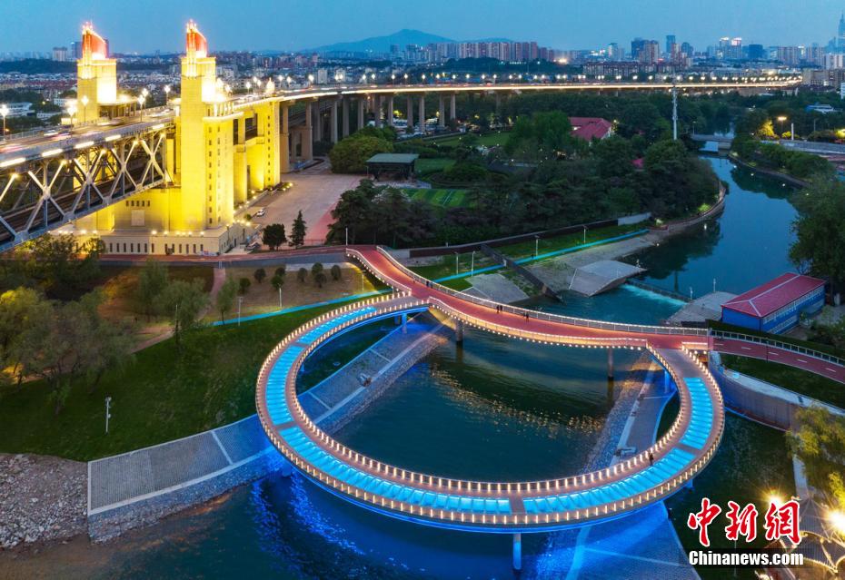 「大きな指輪」のような夜景が人目を引く南京長江大橋に隣接する円形景観橋（撮影・泱波）。