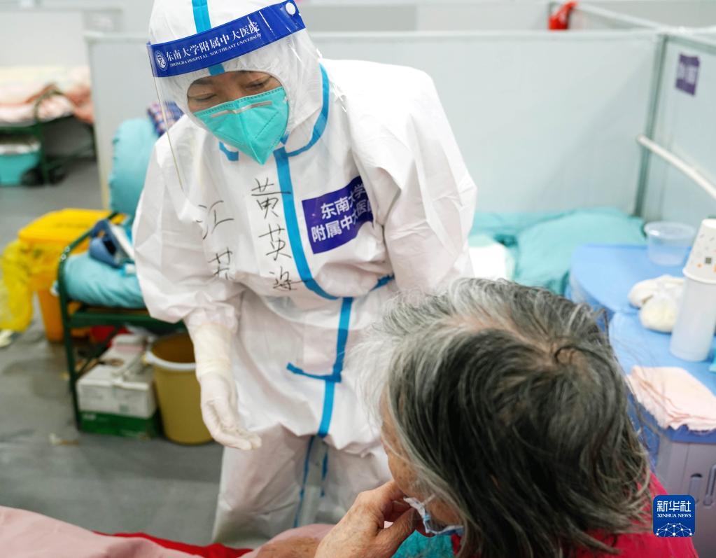 4月25日、上海臨港方艙医院（臨時医療施設）で、薬の服用歴について話し合う高齢の患者と医療スタッフ（撮影・楊有宗）。