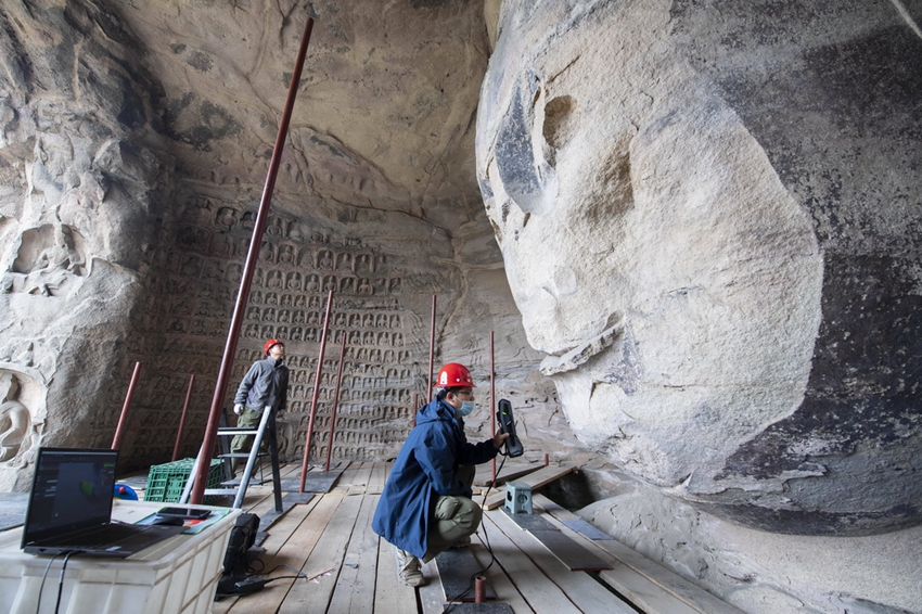 雲崗石窟第17窟で携帯式3Dレーザースキャナーを使って石窟の高精度な立体情報を収集する作業員（ 5月11日、撮影・楊晨光）。