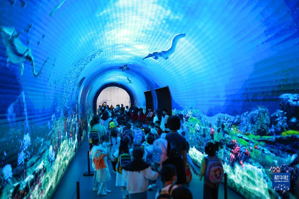 貴州地質博物館を訪れ、液晶ディスプレイに映し出された海底の様子を見学する子供たち（5月31日撮影・劉続）。