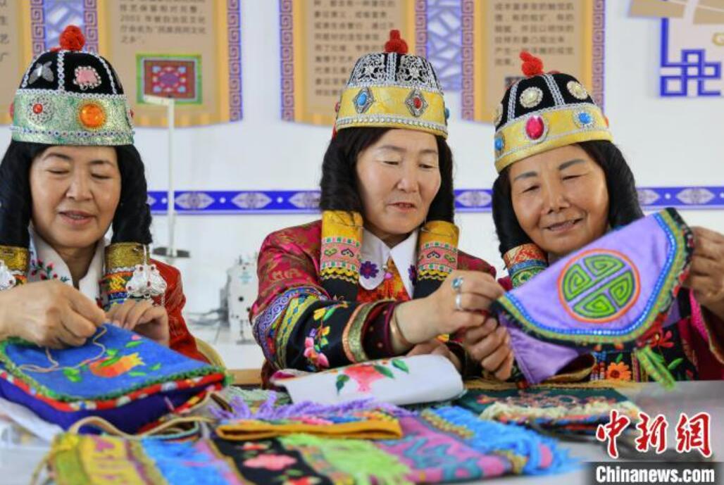 博湖県烏蘭再格森郷烏図阿熱勒村の刺繍合作社で、刺繍技術について意見を交換する刺繍職人の女性たち（撮影・年磊）。
