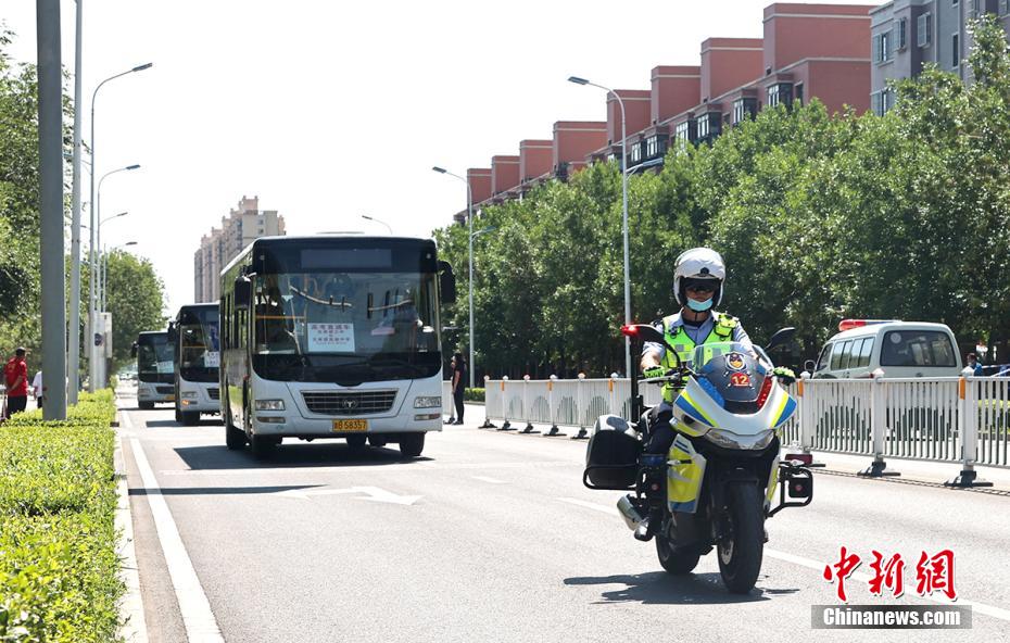 高考実施期間中、交通の秩序を守るべく、受験生が乗るバスを先導する新疆兵団第六師五家渠市の交通警察（摄影・李華北）。