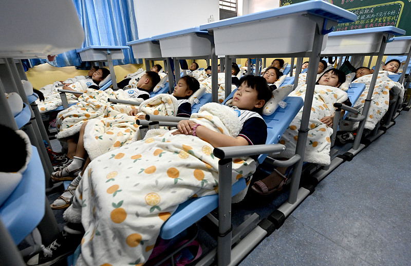 6月13日、河北省邯鄲市叢台区にある東門外小学校の「昼寝用リクライニングチェア」で昼寝をする児童たち（写真著作権はCFP視覚中国が所有のため転載禁止）。