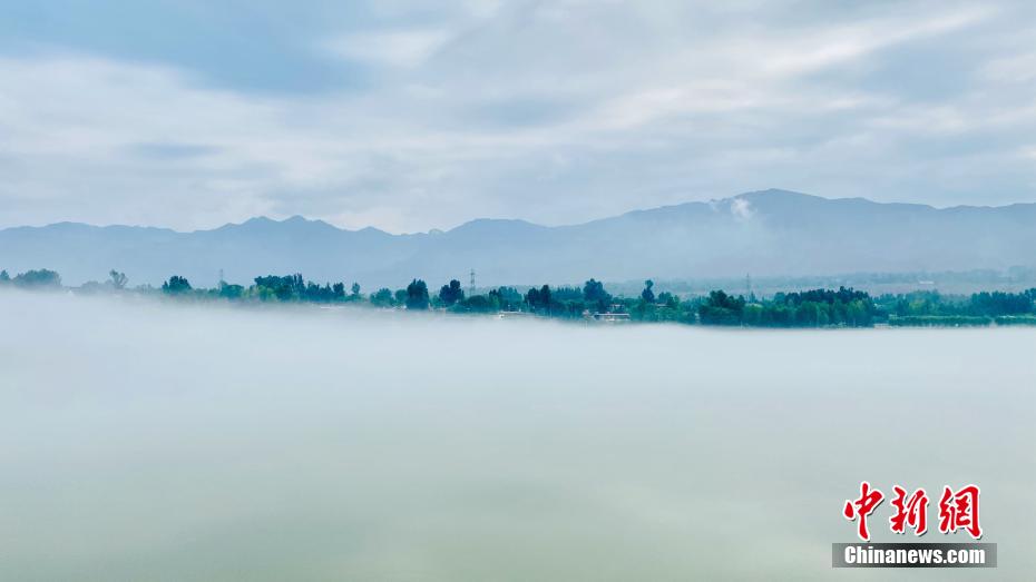 薄霧に連なる山、青々とした木々　青海省尖扎に広がる黄河の夏景色