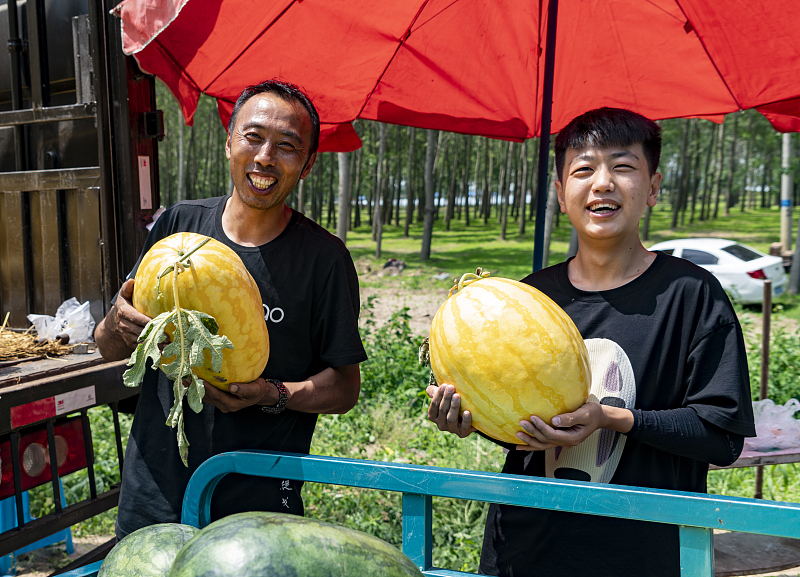 黄色いスイカを見せる農家（写真著作権はCFP視覚中国が所有のため転載禁止）。