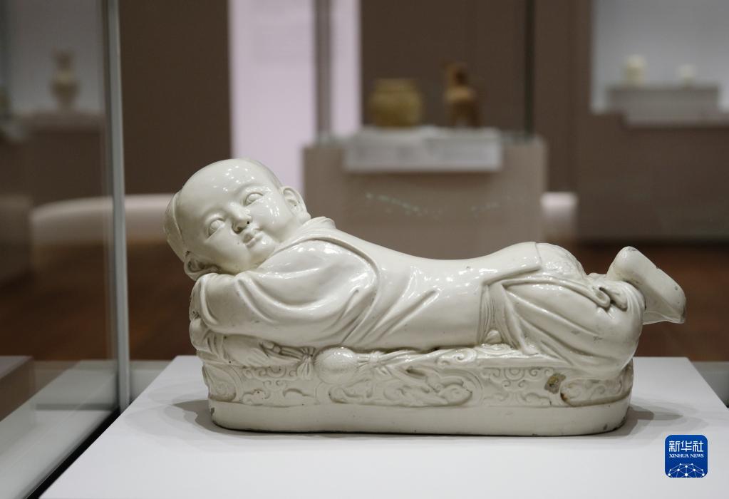 香港故宮文化博物館で展示される北宋時代の定窯白釉子供形古磁枕（6月28日撮影・王申）。