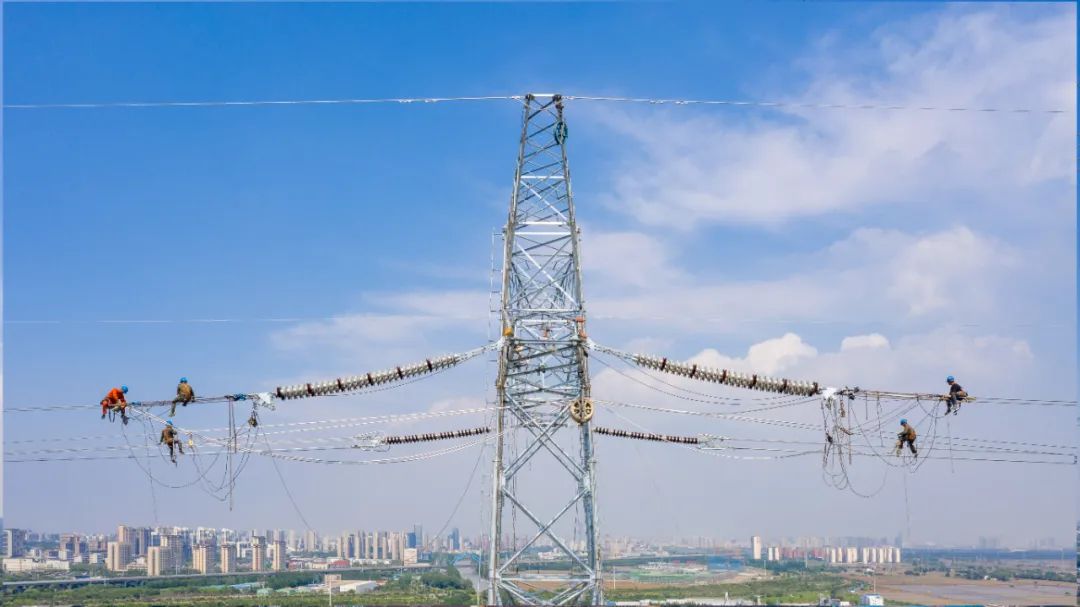 6月15日、130メートル余りの電線を架設する江蘇送変電有限公司の工事作業員。撮影・史俊