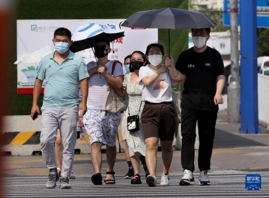 7月10日、炎天下の中、上海市閔行区内を歩く市民。