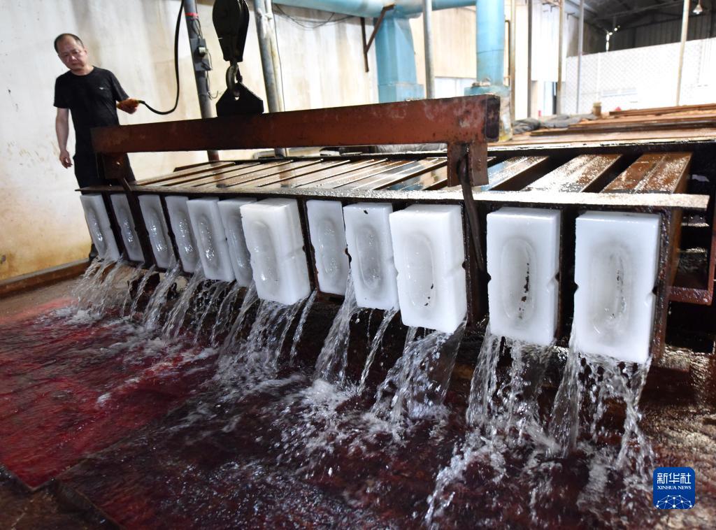7月13日、安徽省巣湖市の製氷工場で、完成した氷を型から取り出す作業員（撮影・馬豊成)。