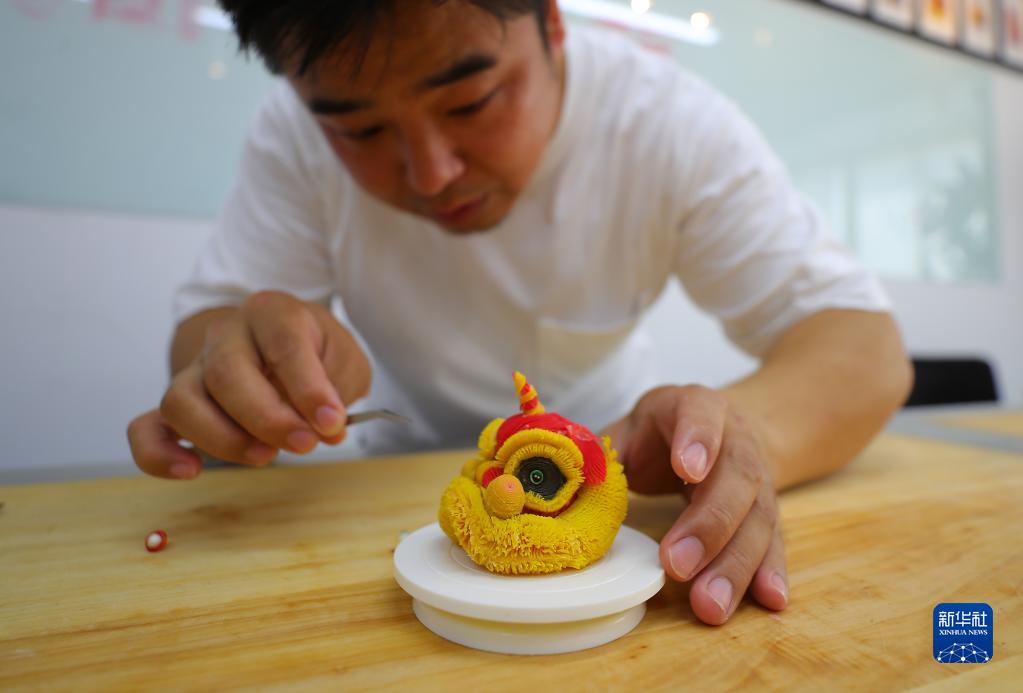 7月14日、アトリエで「醒獅酥」を制作する武楊さん（撮影・楊青）。