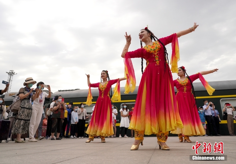 カシュガルに到着した乗客を陽気な民族歌謡と踊りで出迎えるパフォーマーたち（撮影・張珊）。